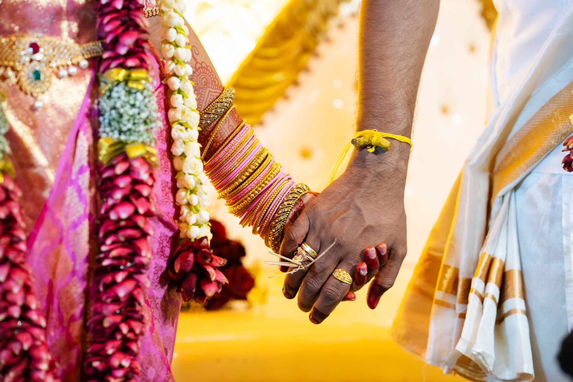 Close up of an Indian couple holding hand on their ritual ceremony in the south Indian traditional